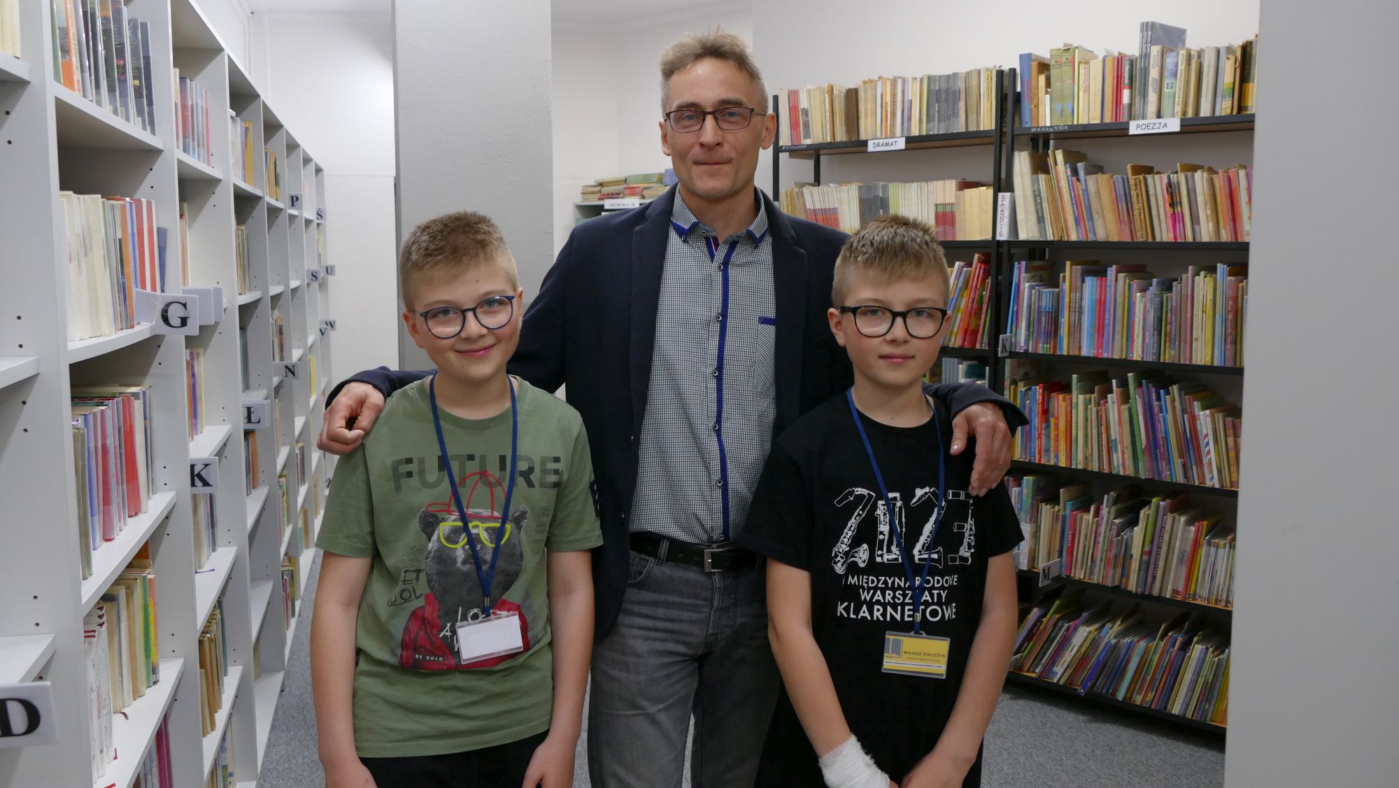 Karol i Miłosz Pielczykowie w towarzystwie Arkadiusza Mroza, od którego otrzymali identyfikatory z tytułem: "Pomocnik bibliotekarza"
